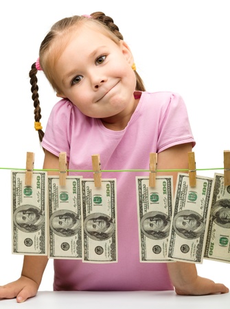 Cute little girl is playing with paper money - dollars, isolated over whiteの写真素材