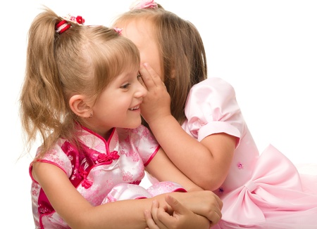 Two little girls are chatting, isolated over whiteの写真素材