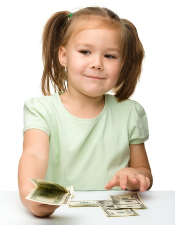 Cute cheerful little girl with paper money - dollars, isolated over whiteの写真素材