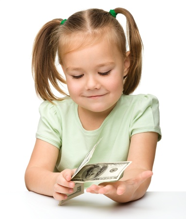 Cute cheerful little girl with paper money - dollars, isolated over whiteの写真素材