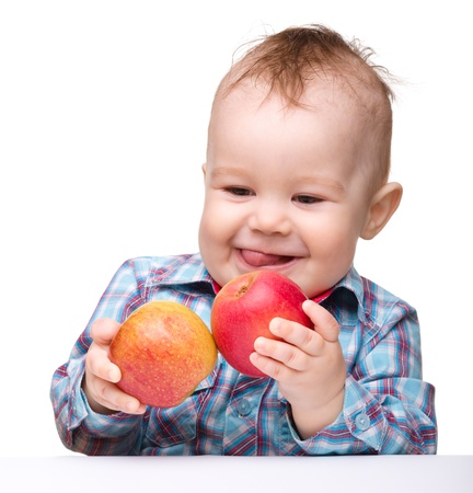 Portrait of a cute little child with two red apples, isolated over whiteの写真素材