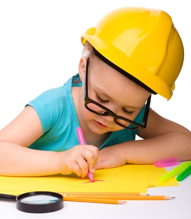Cute little girl draw with marker wearing hard hat, isolated over whiteの写真素材