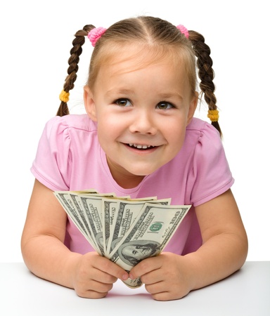 Cute cheerful little girl with paper money - dollars, isolated over whiteの写真素材