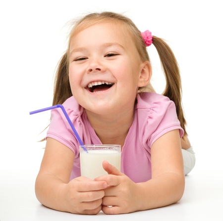 Cute little girl with a glass of milk, isolated over whiteの写真素材