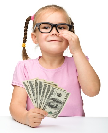 Cute cheerful little girl with paper money - dollars, isolated over whiteの写真素材