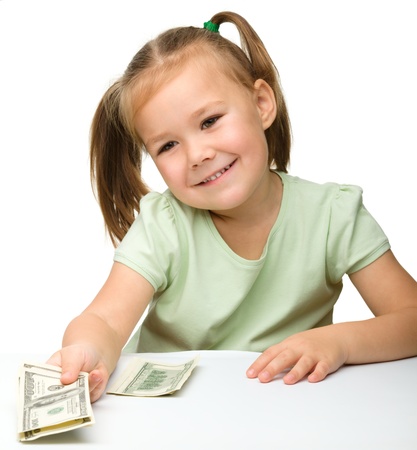 Cute cheerful little girl with paper money - dollars, isolated over whiteの写真素材