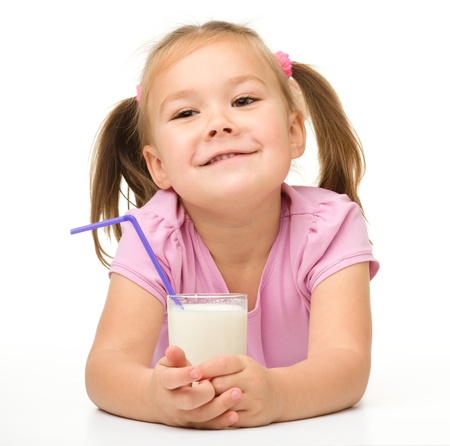 Cute little girl with a glass of milk, isolated over whiteの写真素材