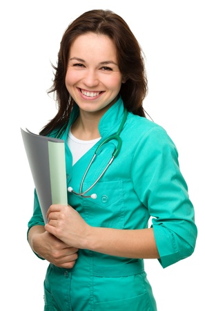 Portrait of a happy young attractive woman wearing doctor uniform, isolated over whiteの写真素材