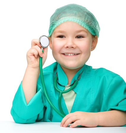 Cute little girl is playing doctor with stethoscope, isolated over whiteの写真素材