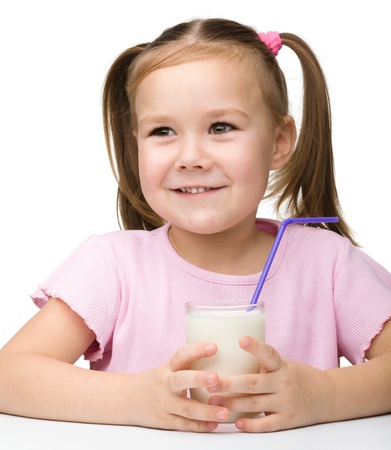 Cute little girl with a glass of milk, isolated over whiteの写真素材