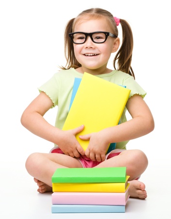 Cute little girl with books, isolated over whiteの写真素材