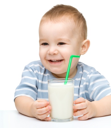 Cute little boy with a glass of milk, isolated over whiteの写真素材