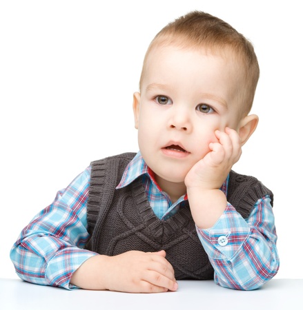 Portrait of a cute and pensive little boy, isolated over whiteの写真素材