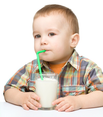 Cute little boy with a glass of milk, isolated over whiteの写真素材