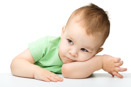 Portrait of a cute and pensive little boy support his head with hand, isolated over whiteの写真素材
