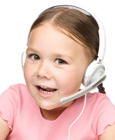 Closeup portrait of cute little girl tackling to customers as a consultant using headset, isolated over whiteの写真素材