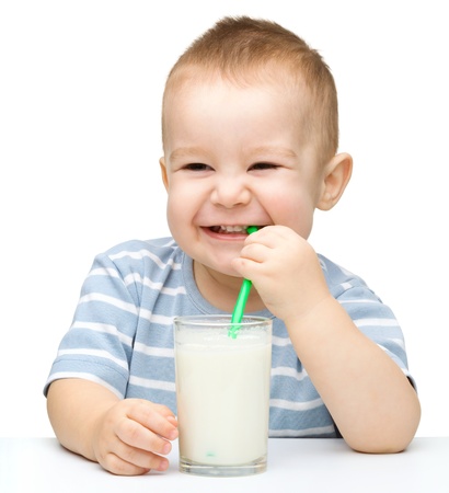 Cute little boy with a glass of milk, isolated over whiteの写真素材