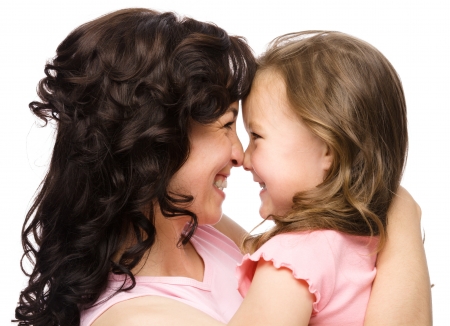 Portrait of happy daughter smiling at her mother, isolated over whiteの写真素材