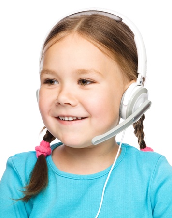 Cute young girl is working as an operator at helpline talking with customer using headset, isolated over whiteの写真素材