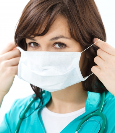 Portrait of a woman in doctor uniform wearing surgical maskの写真素材