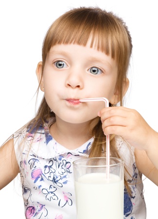 Cute little boy drinks milk using a drinking straw, isolated over whiteの写真素材