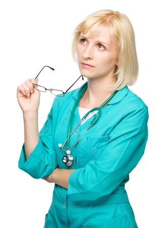 Portrait of a young attractive woman wearing doctor uniform and glasses, isolated over whiteの写真素材