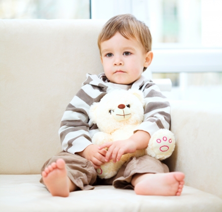 Portrait of a little boy with his teddy bear, indoor shootの写真素材