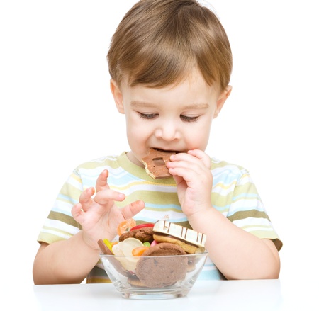 Portrait of a boy with cookies, isolated over whiteの写真素材