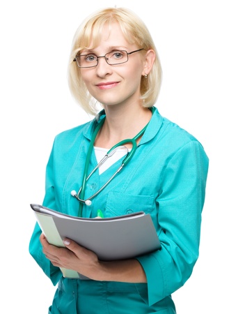Portrait of a young attractive woman wearing doctor uniform and glasses writing prescription, isolated over whiteの写真素材