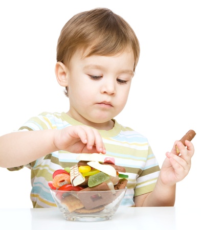 Portrait of a boy with candies, isolated over whiteの写真素材