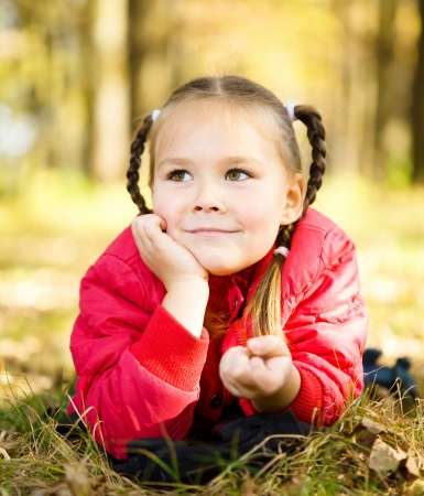 Portrait of a cute little girl in autumn parkの写真素材