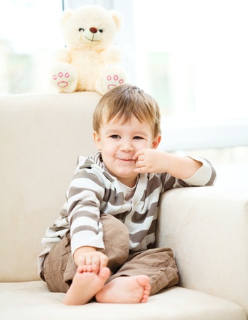 Portrait of a little boy with his teddy bear, indoor shootの写真素材