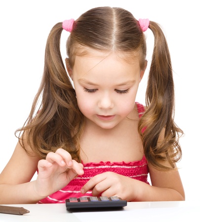 Little girl is using calculator, isolated over whiteの写真素材