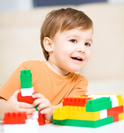 Cute little boy is playing with building blocksの写真素材