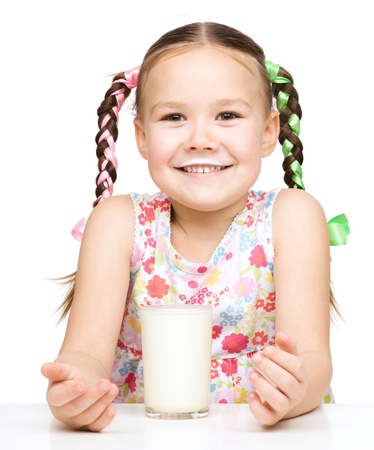 Cute little girl showing milk moustache, isolated over whiteの写真素材