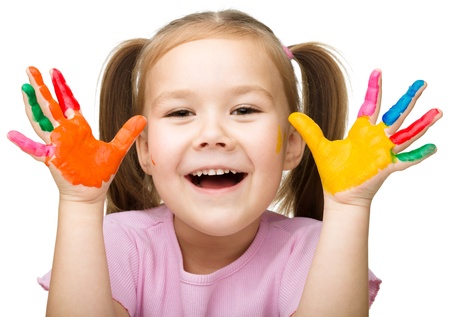 Portrait of a cute cheerful girl showing her hands painted in bright colors, isolated over whiteの写真素材