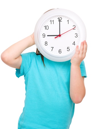 Little girl is holding big clock, isolated over whiteの写真素材