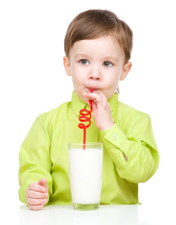 Cute little boy drinks milk using a drinking straw, isolated over whiteの写真素材