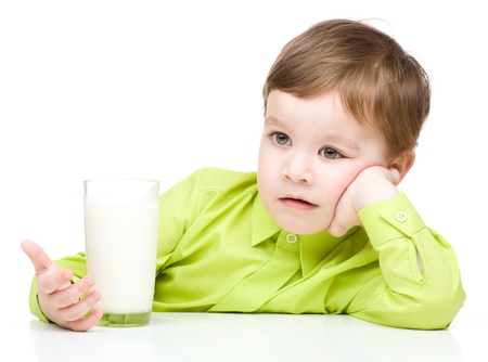 Cute little boy drinks milk using a drinking straw, isolated over whiteの写真素材