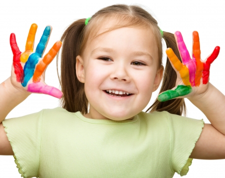 Portrait of a cute cheerful girl showing her hands painted in bright colors, isolated over whiteの写真素材