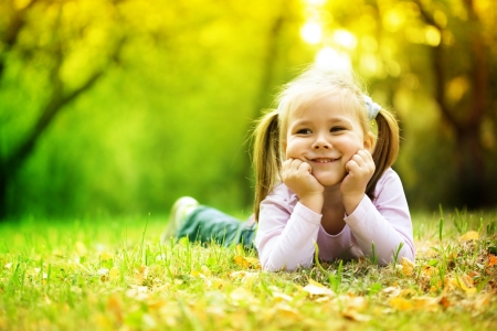 Portrait of a cute little girl in autumn parkの写真素材