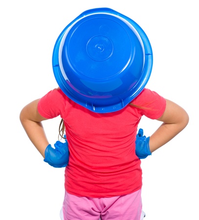 Little girl put a blue bucket on her head, tired of cleaning concept, isolated over whiteの写真素材