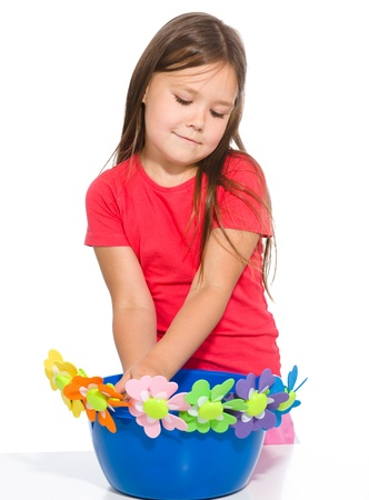 Little girl is playing with flowers, isolated over whiteの写真素材