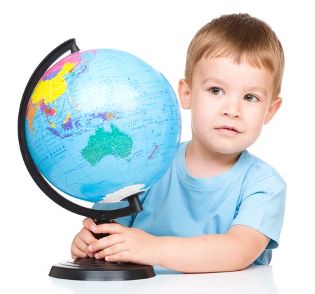 Happy little boy with a globe, isolated over whiteの写真素材
