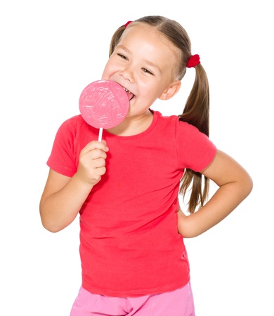 Happy little girl with big lollipop, isolated over whiteの写真素材