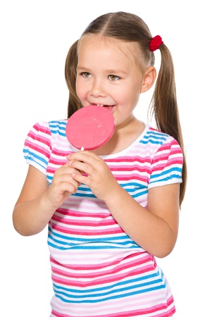 Happy little girl with big lollipop, isolated over whiteの写真素材