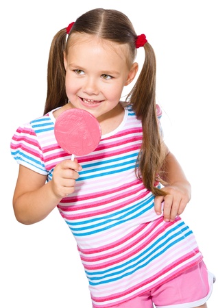 Happy little girl with big lollipop, isolated over whiteの写真素材