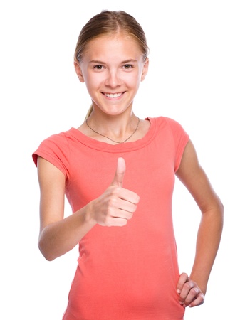 Young girl dressed in red is showing thumb up gesture, isolated over whiteの写真素材
