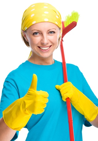 Young woman as a cleaning maid holding broom and showing thumb up gesture, isolated over whiteの写真素材