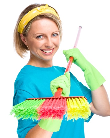 Young woman as a cleaning maid holding broom, isolated over whiteの写真素材